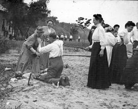 Beach event-- Group of women with kneeling man