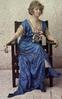 Woman in a blue boat neck dress sitting in a chair