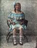 Woman with blue boatneck dress sitting in a chair