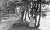 Woman posing with trees on bank of a river