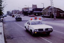 Police car leading vintage cars